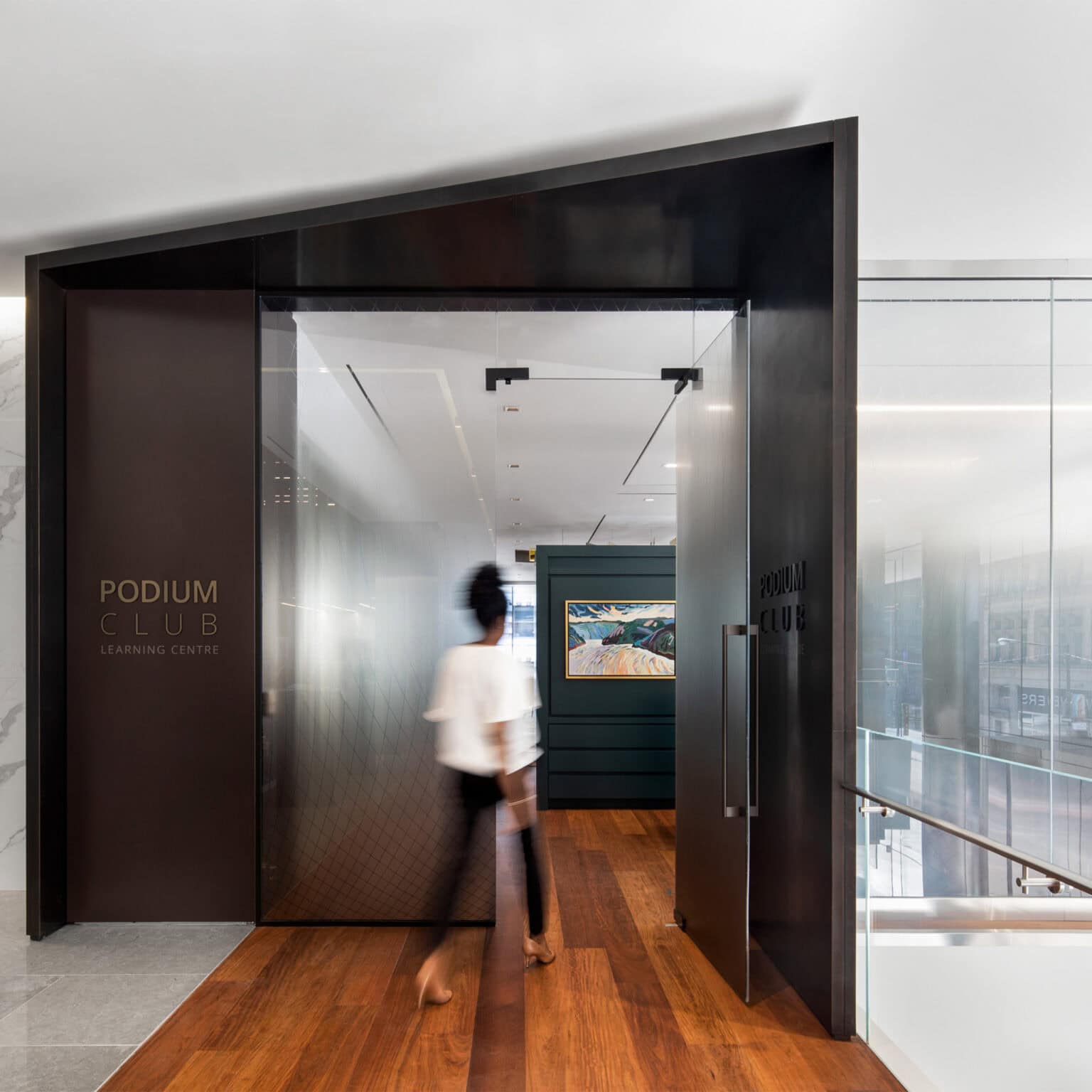 Deloitte Podium Club entryway with wood surrounds and stainless steel doors.