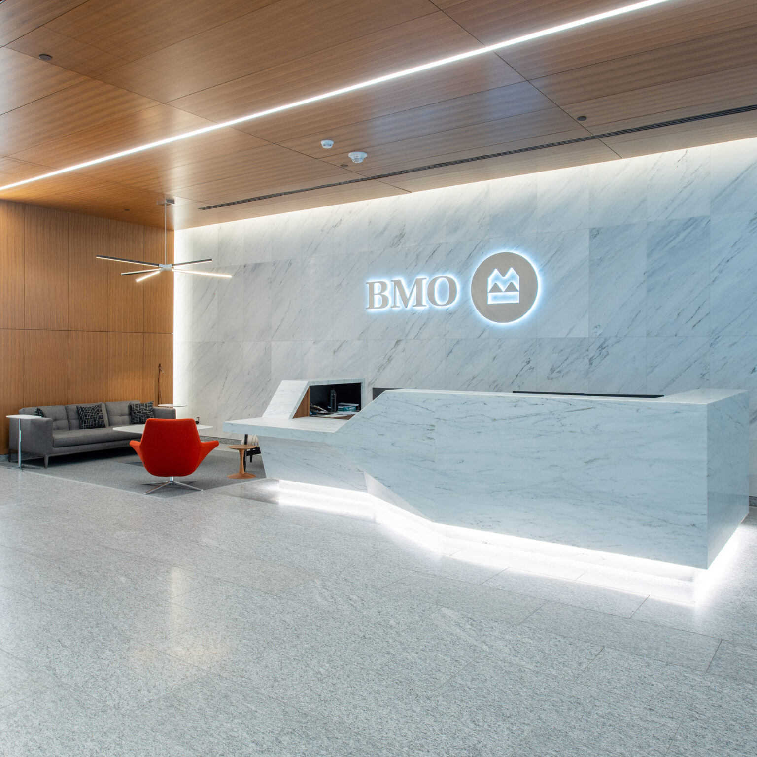 BMO marble lobby with BMO branding on the wall behind the reception desk.