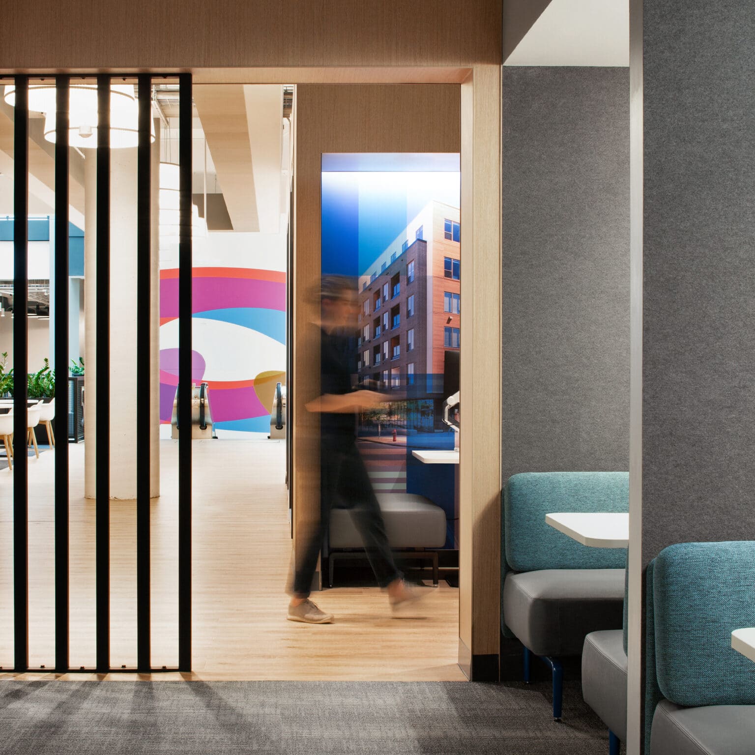 Workstation booths with a view of a cityscape graphic with person walking through in the background