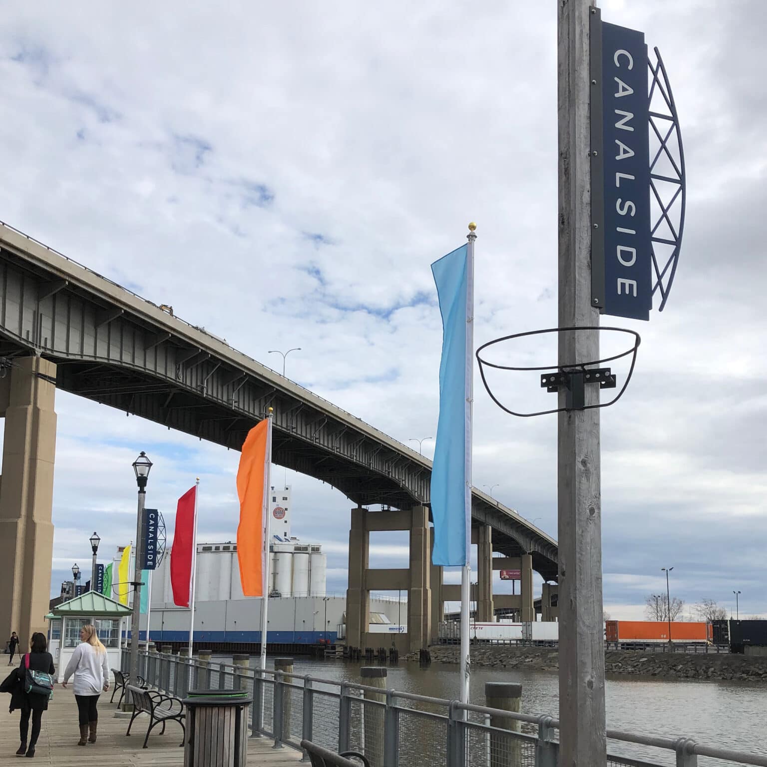 View of Canalside with highway overpass, boardwalk, and a Canalside sign.