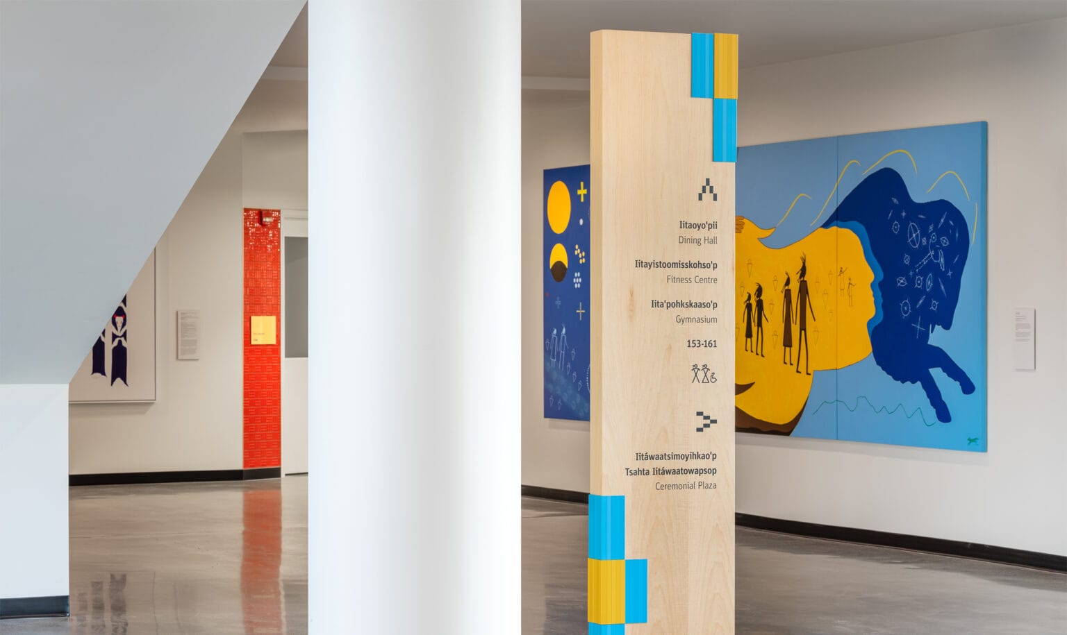 Freestanding directional sign surrounded by artwork.