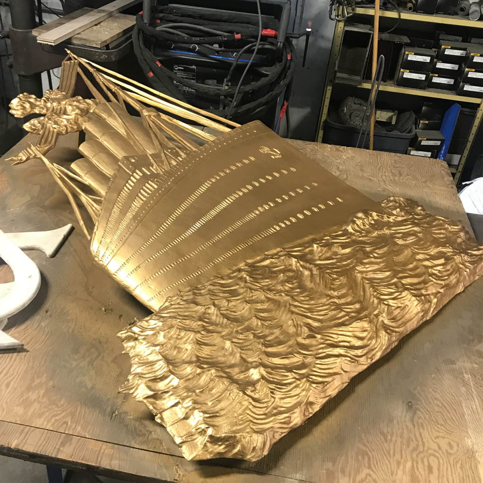 Restored bronze steam ship on workshop table.