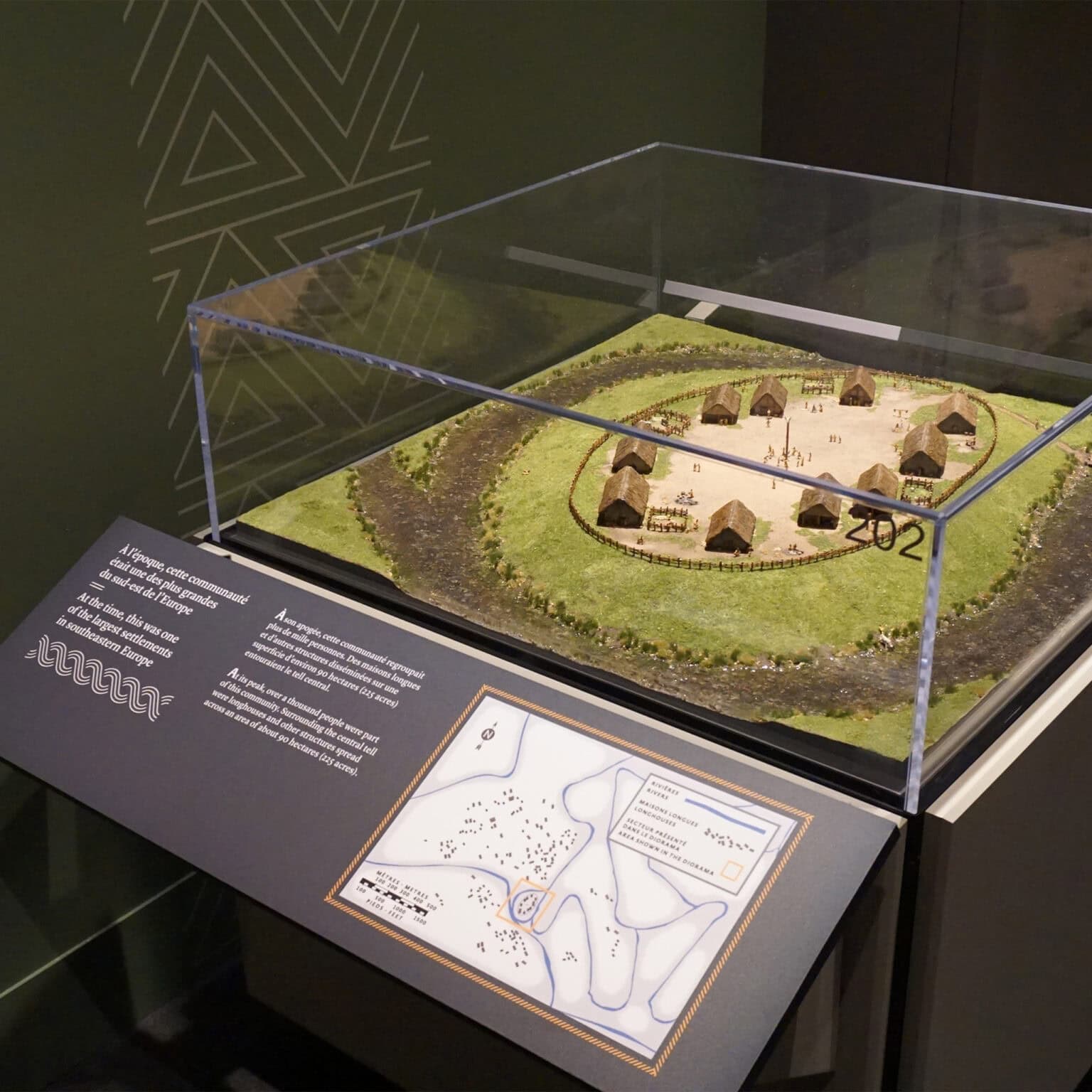 Canadian Museum of History First Royals of Europe exhibit featuring exhibit case containing model of a settlement and corresponding information panel with copy and a map designed by Entro.