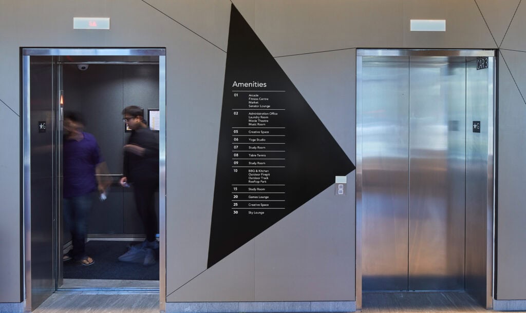 McMaster University 10 Bay Student Residence residential elevator lobby featuring wall-mounted geometric directory sign.