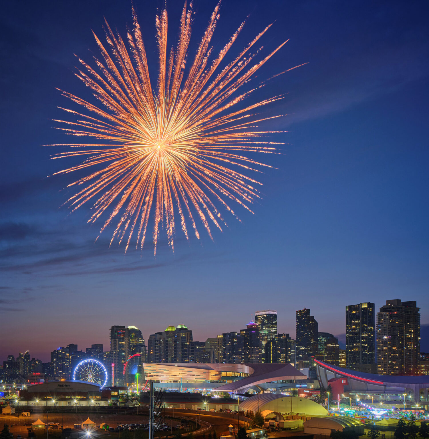 Drone shot of BMO Centre site at night, with ferris wheel and fireworks.